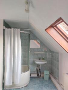 a bathroom with a bath tub and a sink at Hangya panzió in Tîrgu Secuiesc