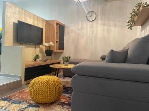 a living room with a couch and a tv at Pomerino Apartmans in Pomer