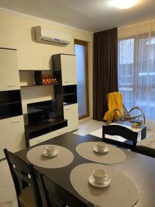 a living room with a dining room table and a kitchen at Marina Park OLIWIA in Sveti Vlas