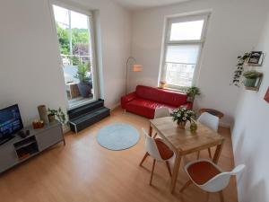 a living room with a red couch and a table at Wohnung am Schlosspark in Bendorf