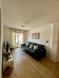 un soggiorno con un divano blu e una TV di Apartamento Avigar con vistas a la montaña y piscina a Cómpeta