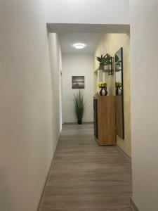 a hallway with white walls and a wooden partition with flowers at Pomerino Apartmans in Pomer