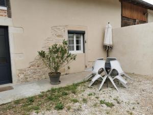 two chairs and an umbrella next to a house at Gîte in Saint-Bénigne