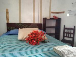 a bouquet of red flowers sitting on top of a bed at Hotel Hostal Teresa in Zipolite +23 photos