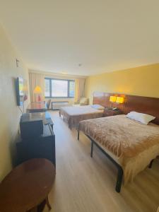 a hotel room with two beds and a table at Hilltop Inn in Barre +12 photos