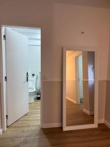 an open door to a bathroom with a mirror at Casa de Ferias apartamento T3 in Carregado