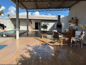 a patio with a table and chairs and a grill at Casa 2min do Centro c Piscina in Bonito