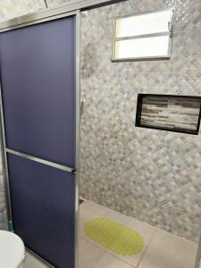 a shower with a blue door in a bathroom at Casa 2min do Centro c Piscina in Bonito
