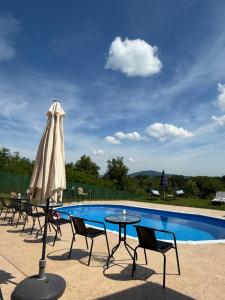 a pool with chairs and a table and an umbrella at Kares house in Belgrade