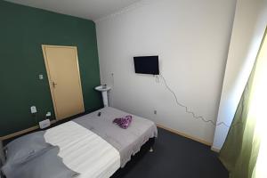 a small room with a bed and a television at Studio Niterói-Barcas 604 in Niterói
