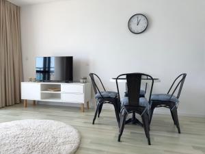 jadalnia z 2 krzesłami, stołem i zegarem w obiekcie Apartment Alegria complex Carpe Diem Balchik w Bałcziku