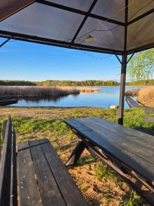 a picnic table with an umbrella in front of a lake at Atpūtas vieta Sīvera Medniekkrasti 