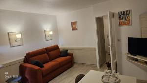 a living room with a couch and a television at St RAPHAEL VALESCURE CASA in Saint-Raphaël