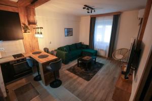 a living room with a green couch and a table at Zeus Apartman in Jagodina