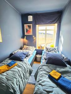 ベルゲンにあるHome is where your heart is!の青い壁と窓のある部屋にベッドが2つある