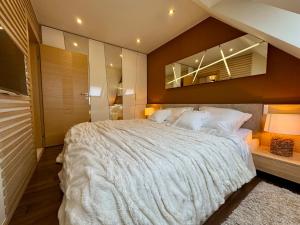a bedroom with a large bed and a mirror at AVIRA Apartman with Free Private Garage in Nyíregyháza