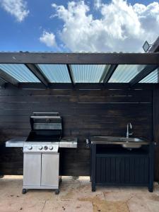 a outdoor kitchen with a stove and a sink at Savannah suite in ‘Isfiyā