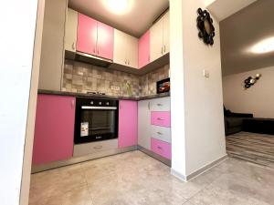 a kitchen with pink and purple cabinets at Studio Navae in Năvodari