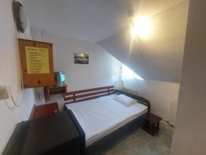 a small room with a small bed and a desk at Hangya panzió in Tîrgu Secuiesc