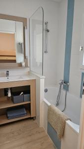 a bathroom with a tub and a sink and a bath tub at St RAPHAEL VALESCURE CASA in Saint-Raphaël