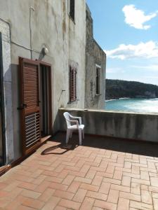 ein weißer Stuhl auf einer Terrasse neben einem Gebäude in der Unterkunft Appartamenti Castello in Peschici