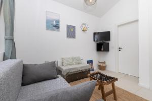 a living room with a gray couch and a chair at Nonna Vittoria 2 in Mali Lošinj