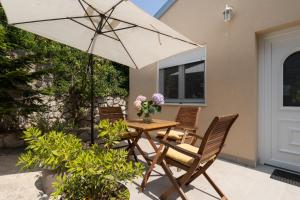 a table and chairs with an umbrella on a patio at Nonna Vittoria 2 in Mali Lošinj