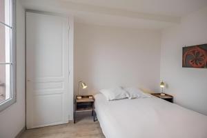 a white bedroom with a white bed and a window at Balnéo hyper centre, Calme, Equipé, Proche gare, Wifi in Troyes +10 photos