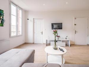 a white living room with a couch and a table at Balnéo hyper centre, Calme, Equipé, Proche gare, Wifi in Troyes