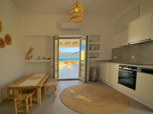 a kitchen with a wooden table and a tableasteryasteryasteryasteryasteryasteryastery at Farous seaside sunset villa II in Andiparos
