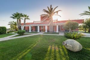 a large building with palm trees in the yard at Bed & Breakfast Villa Michela Alezio in Alezio