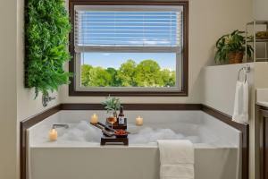 a bath tub with candles in a bathroom with a window at Entire 4br Private Home I-85 Access Family in Duluth +50 photos