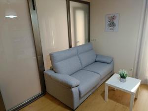 a living room with a blue couch and a table at Piso PLAYA CANGAS CENTRO in Cangas de Morrazo