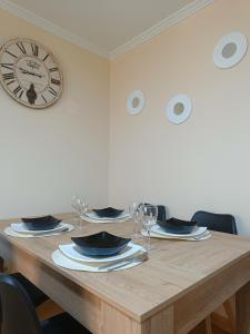 a table with wine glasses and a clock on the wall at Piso PLAYA CANGAS CENTRO in Cangas de Morrazo