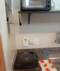 a kitchen counter with a microwave on a shelf at Studio 1103 - Centro Niterói in Niterói +18 photos