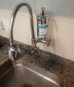 a kitchen sink with water coming out of a faucet at Studio 1103 - Centro Niterói in Niterói