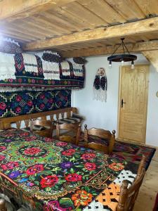 a bedroom with a bed with a colorful blanket at Casuța din Grădină in Breb
