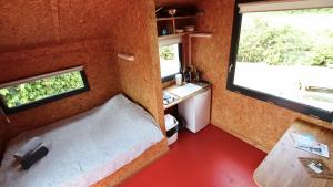 a small room with a bed and a desk and a window at eco lodges of Mont Bernanchon in Mont-Bernenchon