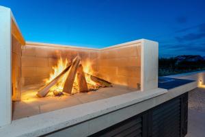 a brick fireplace with a fire in it at NEW! Luxury Villa Golden Hour near the beach with heated pool and sauna - TA Leut agency in Privlaka