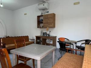 a living room with a table and chairs and a cabinet at Morina Rooms in Durrës