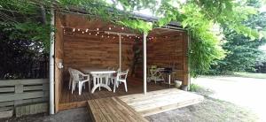 a wooden pergola with a table and chairs at Maison Parentis en Born 6-8 personnes-L'échappée landaise in Parentis-en-Born