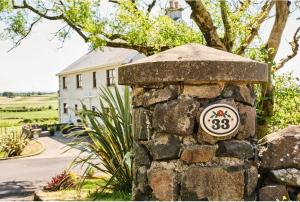 a stone wall with a house in the background at Carnbore House BnB in Bushmills