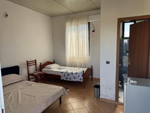 a small room with two beds and a window at Morina Rooms in Durrës