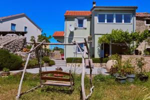 un columpio en un patio frente a una casa en Green House, en Nerezine 35 fotos más