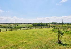 a fence in a field with green grass at Carnbore House BnB in Bushmills