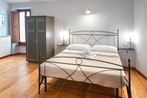 a bedroom with a bed with a black metal frame at La casetta affittacamere in Bevagna