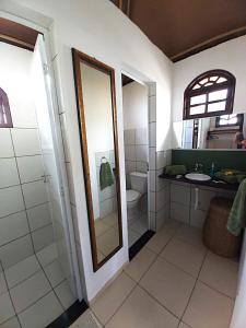 a bathroom with a toilet and a sink and a mirror at Bangalô Panorâmica in Conde +30 photos