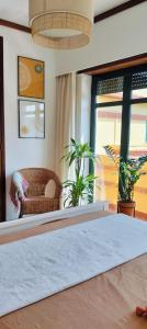 a bedroom with a bed and a couch and a window at Boho Beach Apartment in Praia de Mira