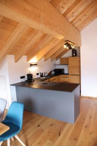 a kitchen with a counter and a blue chair at Ferienwohnungen Göhl in Bad Hindelang