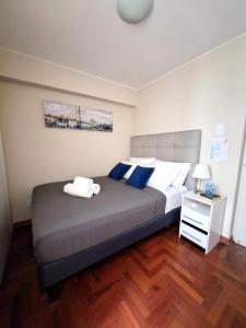 a bedroom with a large bed with blue and white pillows at Room in shared apartment - Shared Bathroom 402 in Lima